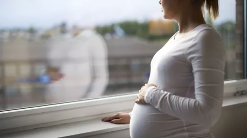 femme enceinte devant une fenêtre